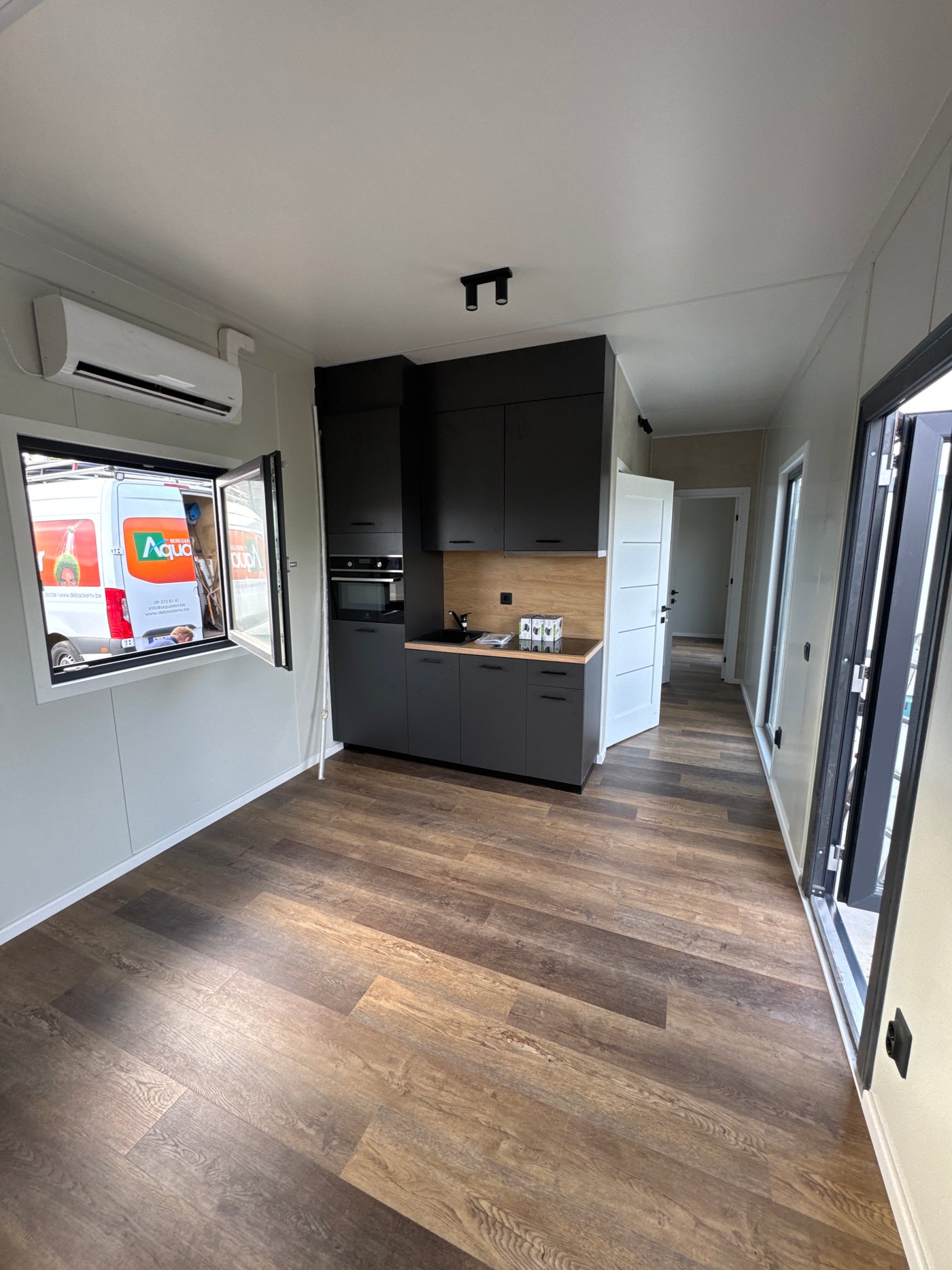 Gerealiseerde woonunit van 13 × 3,2 meter in Lievegem, België met twee slaapkamers, complete keuken en gescheiden badkamer en toilet