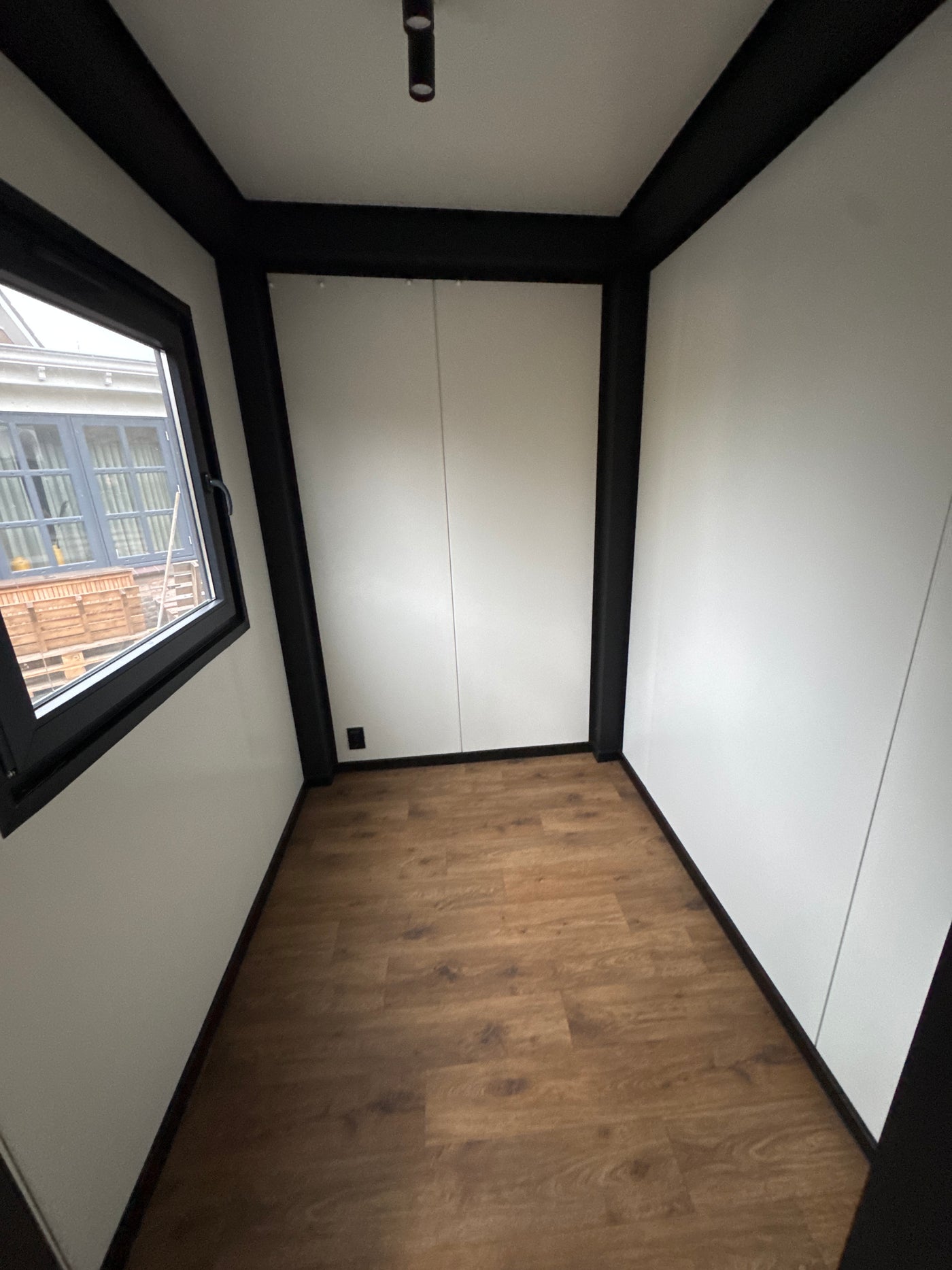Direct leverbare woonunit van 6,5 × 3,2 meter geplaatst in Buitenpost met slaapkamer, keuken en badkamer