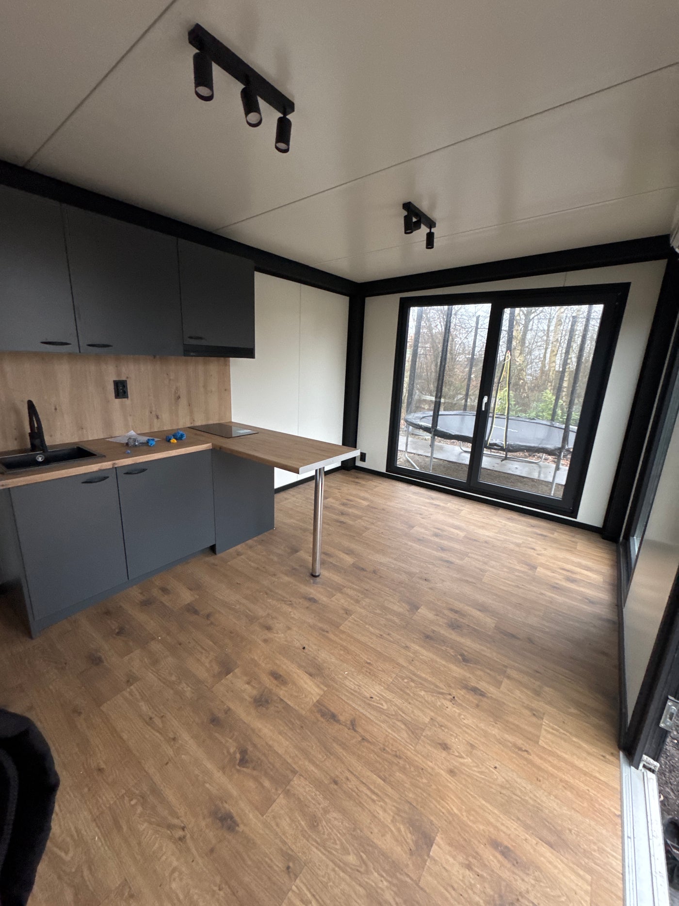 Direct leverbare woonunit van 6,5 × 3,2 meter geplaatst in Buitenpost met slaapkamer, keuken en badkamer
