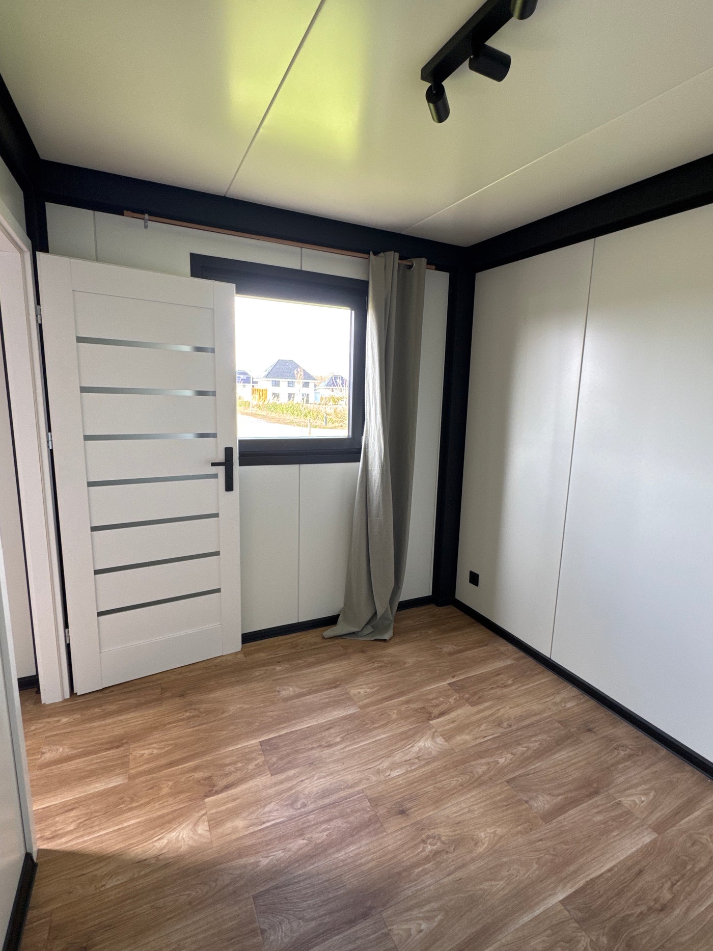 Woonunit van 8 × 3,2 meter geplaatst in Almere met antraciet gevel en houtlook gevelaccenten