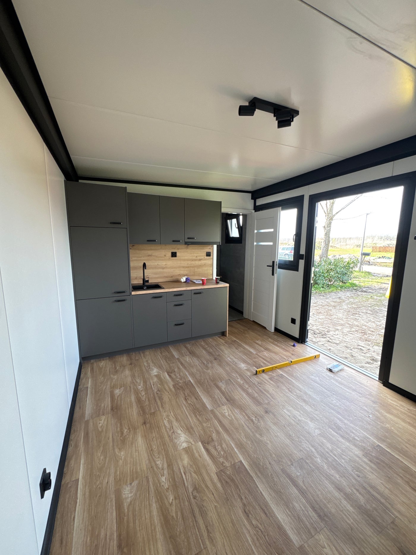Woonunit van 8 × 3,2 meter geplaatst in Almere met antraciet gevel en houtlook gevelaccenten