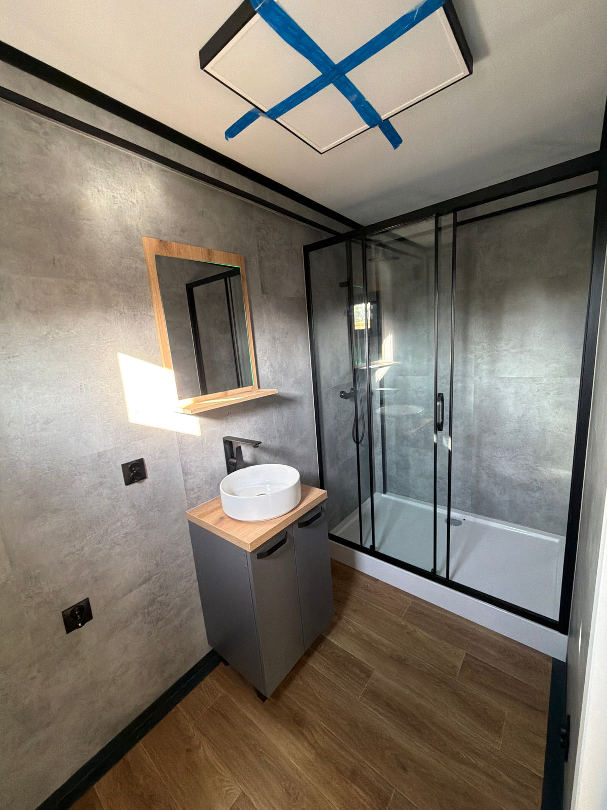 Kantoorunit van 9 × 3,2 meter in Hoogvliet met donkere gevel, houtlook accenten en complete sanitaire voorzieningen
