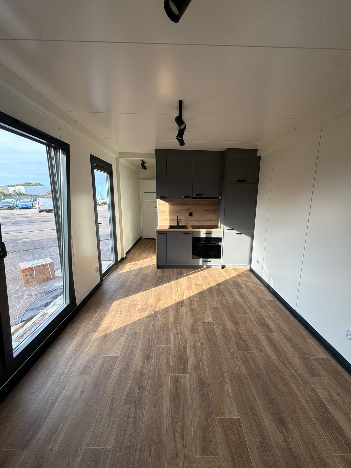 Kantoorunit van 9 × 3,2 meter in Hoogvliet met donkere gevel, houtlook accenten en complete sanitaire voorzieningen