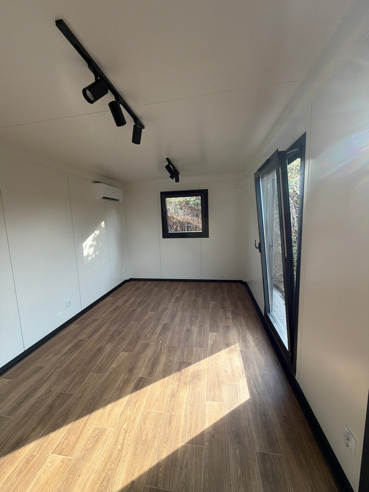 Kantoorunit van 9 × 3,2 meter in Hoogvliet met donkere gevel, houtlook accenten en complete sanitaire voorzieningen