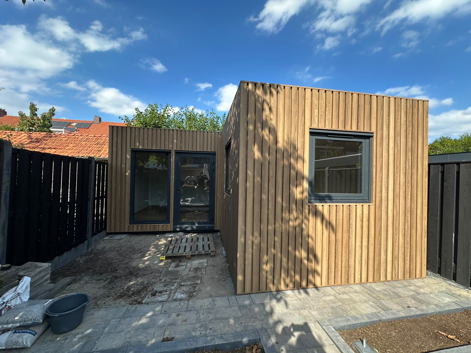 L-vorm woonunit in Roosendaal met houten gevelbekleding, groene maatwerk keuken en complete badkamer